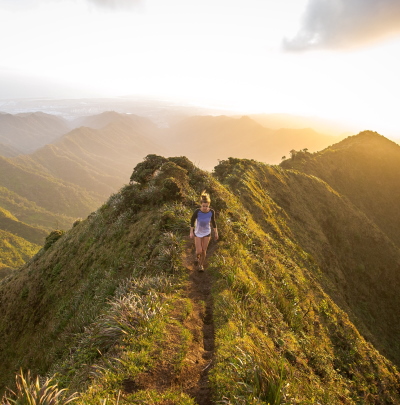 A girl walking on a hiking track on the top of a mountain